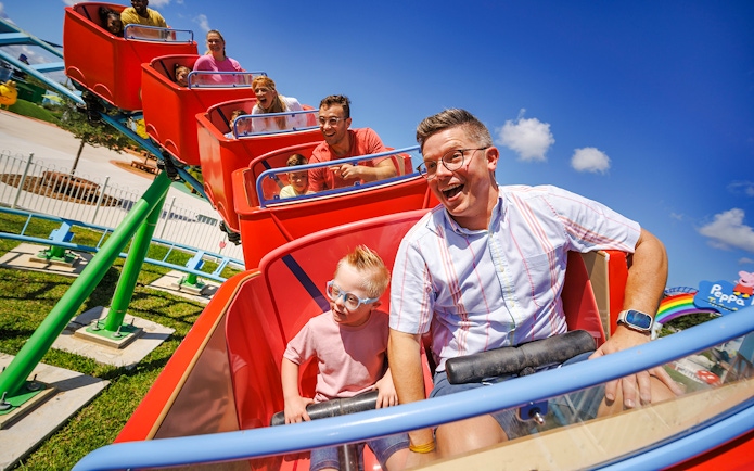 Families enjoying a roller coaster ride at Peppa Pig Theme Park, Florida.