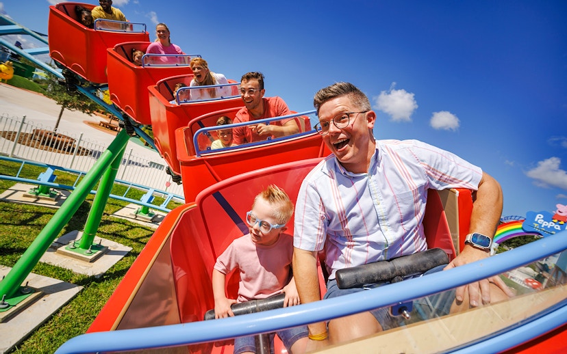 Families enjoying a roller coaster ride at Peppa Pig Theme Park, Florida.