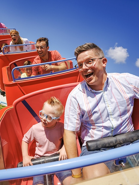 Families enjoying a roller coaster ride at Peppa Pig Theme Park, Florida.