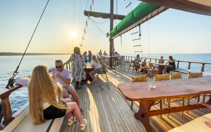 Guests enjoying a sunset cruise on a boat with open bar and buffet near Ayia Napa.