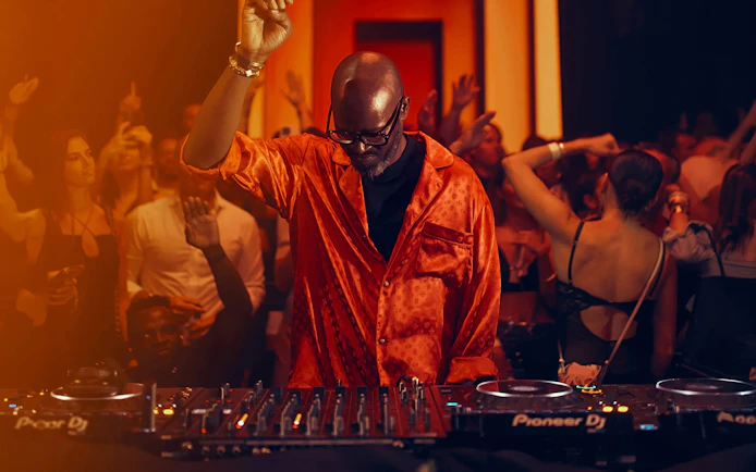 DJ performing at Black Coffee event, Hi Ibiza nightclub, with crowd dancing.