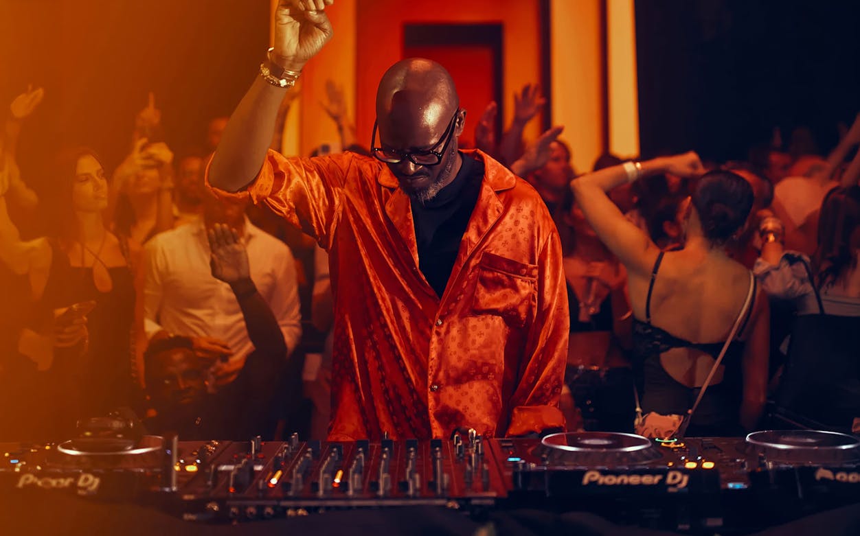 DJ performing at Black Coffee event, Hi Ibiza nightclub, with crowd dancing.