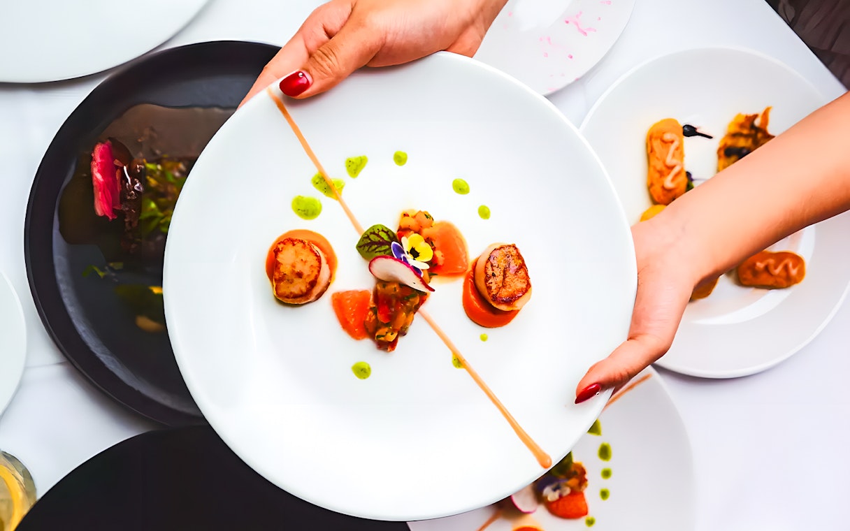 Scallops and garnishes served on a plate during the Gold Penfolds Dinner & Drinks Cruise, Sydney Harbour.