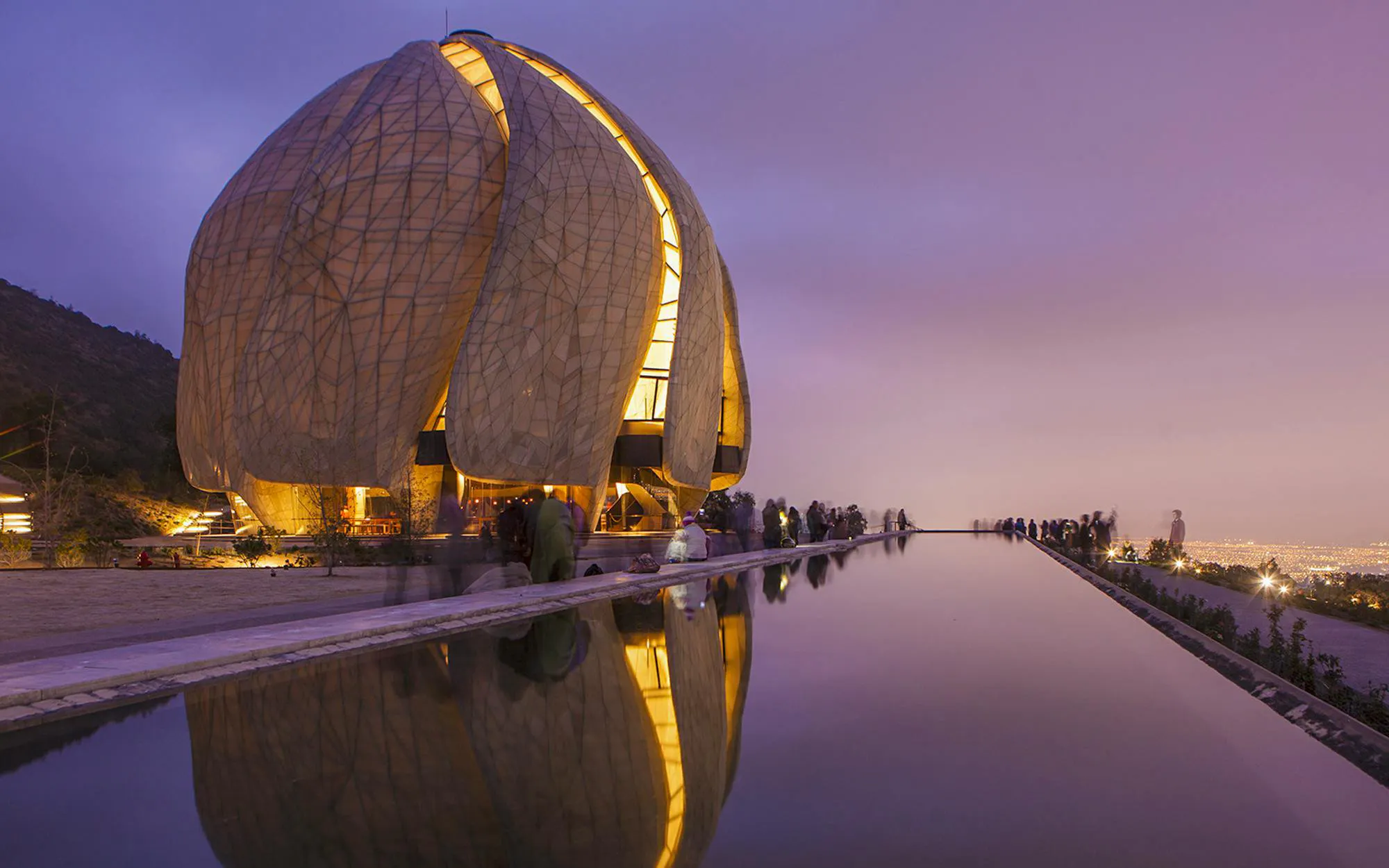 Baháʼí House of Worship in Santiago, Chile, illuminated at dusk with reflection pool.