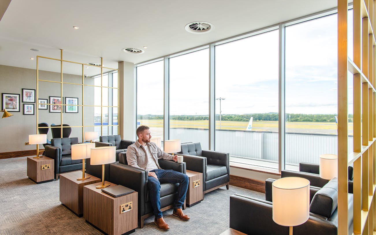 Lounge seating area with a view of the runway at Plaza Premium Lounge, Edinburgh Airport.