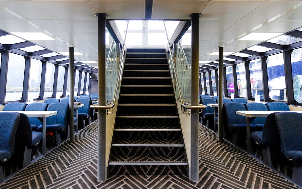 Interior seating area of Sinbad ship on Milford Sound cruise with central staircase.