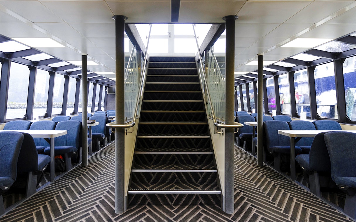 Interior seating area of Sinbad ship on Milford Sound cruise with central staircase.