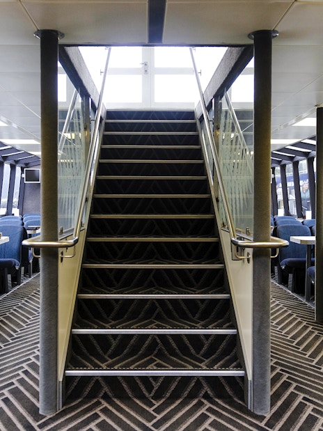 Interior seating area of Sinbad ship on Milford Sound cruise with central staircase.