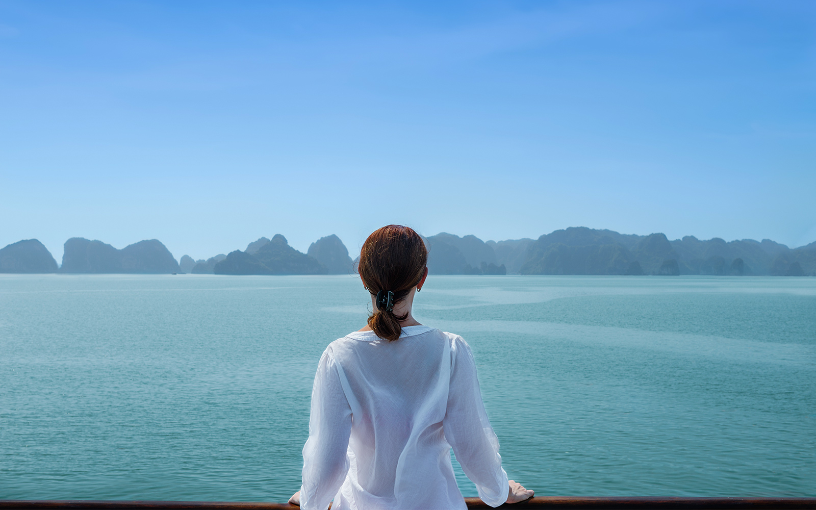 Sightseeing cruise boat on a river with city skyline in the background, showcasing global tour experience.