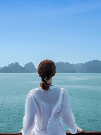 Sightseeing cruise boat on a river with city skyline in the background, showcasing global tour experience.