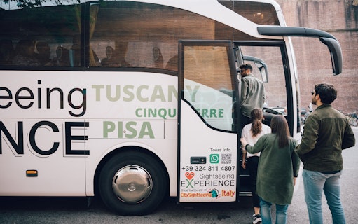 Tourists boarding a sightseeing bus for a day trip to Cinque Terre, Italy.