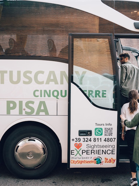 Tourists boarding a sightseeing bus for a day trip to Cinque Terre, Italy.