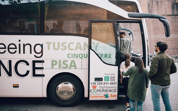 Tourists boarding a sightseeing bus for a day trip to Cinque Terre, Italy.