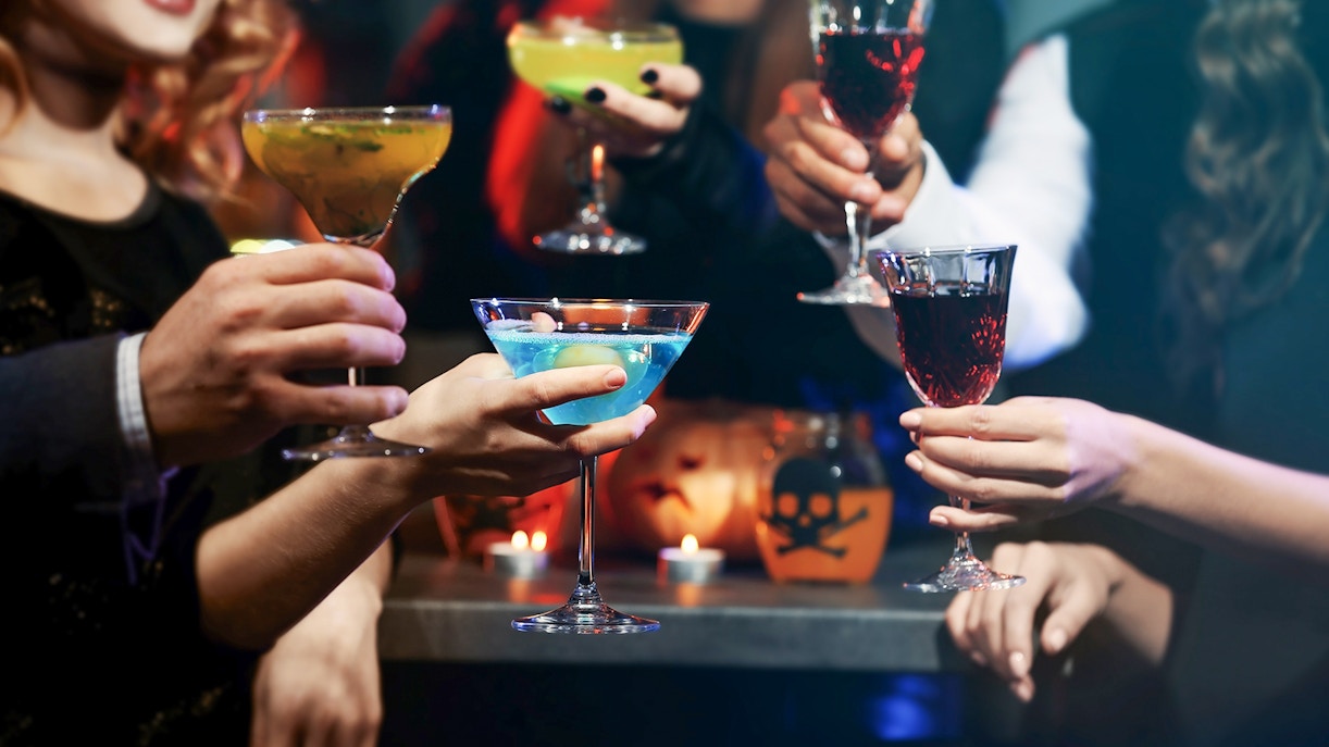 People toasting with colorful cocktails at a festive gathering.