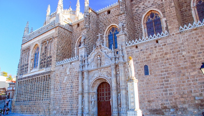 Monasterio de San Juan de los Reyes exterior with intricate Gothic architecture in Toledo, Spain.