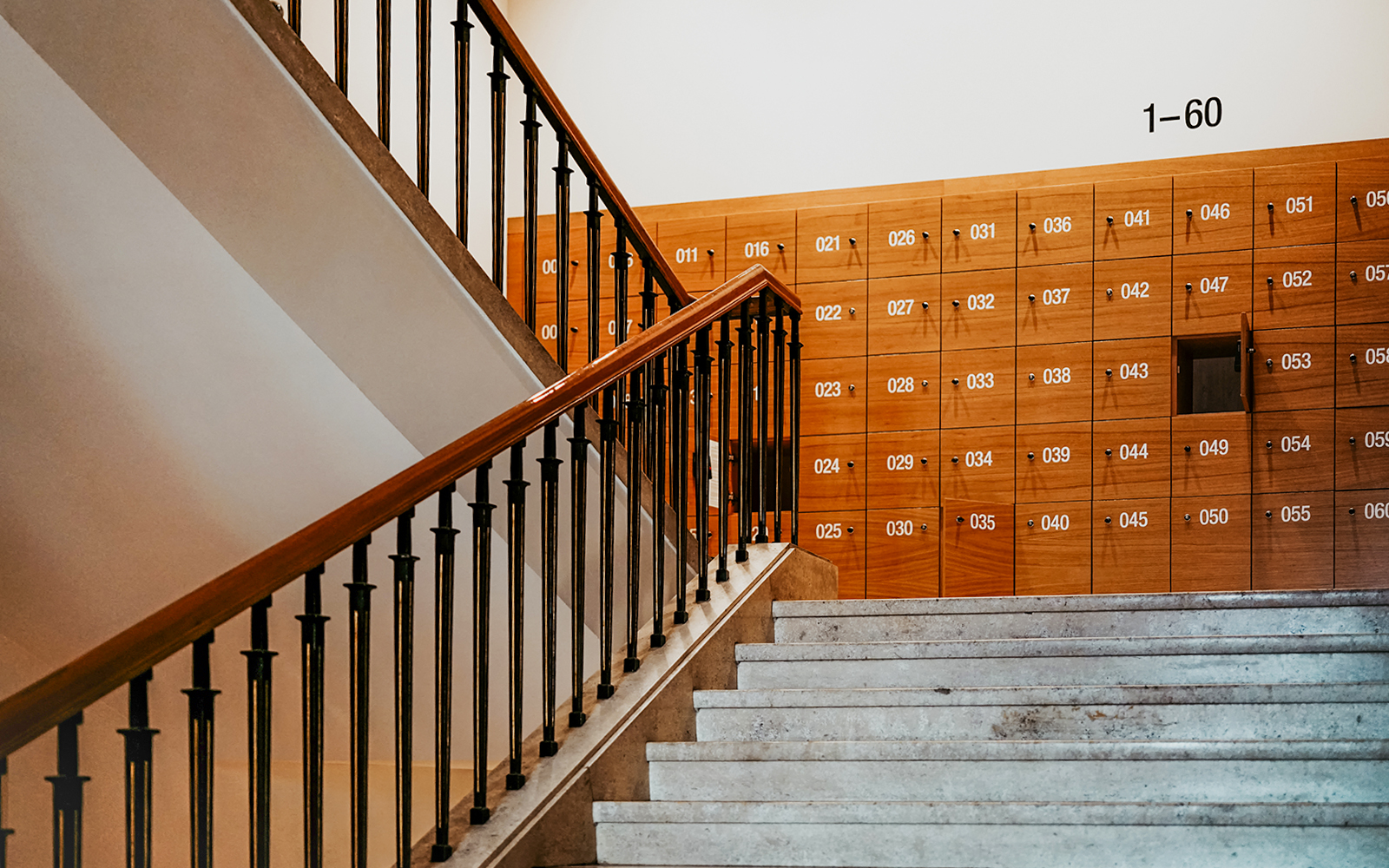 Museum cloakroom with numbered lockers and staircase.