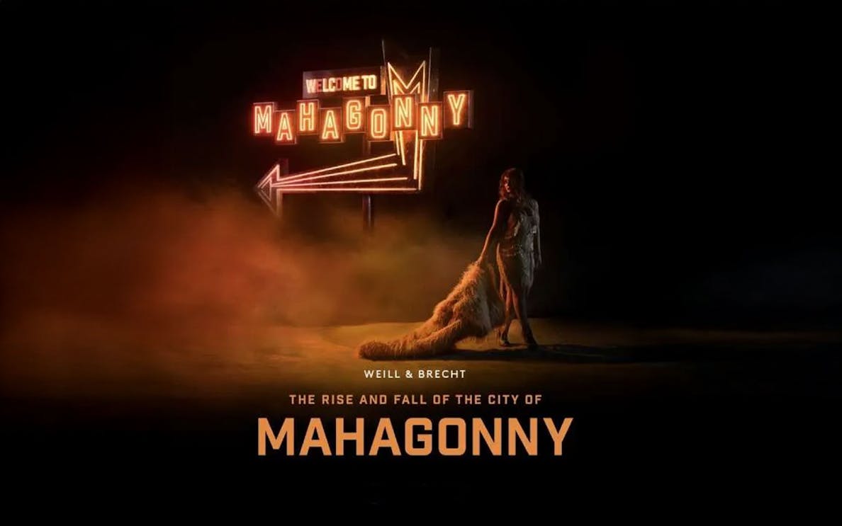Stage set for "The Rise and Fall of The City of Mahagonny" opera performance, featuring dramatic lighting and urban backdrop.