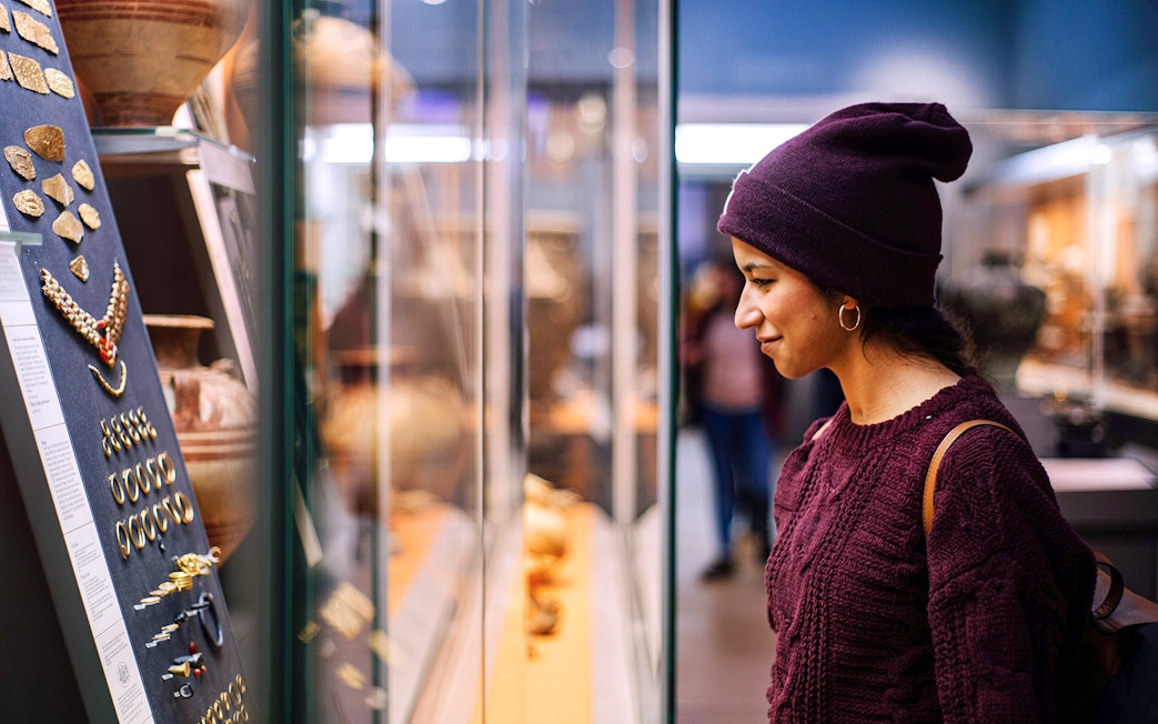 Visitor examining ancient artifacts at the British Museum during a guided tour.
