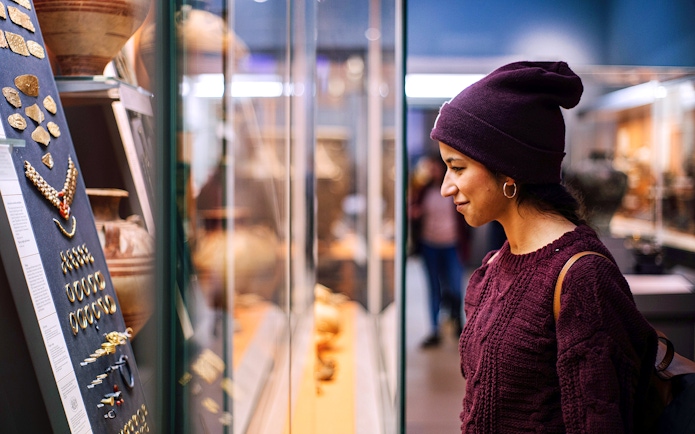 Visitor examining ancient artifacts at the British Museum during a guided tour.