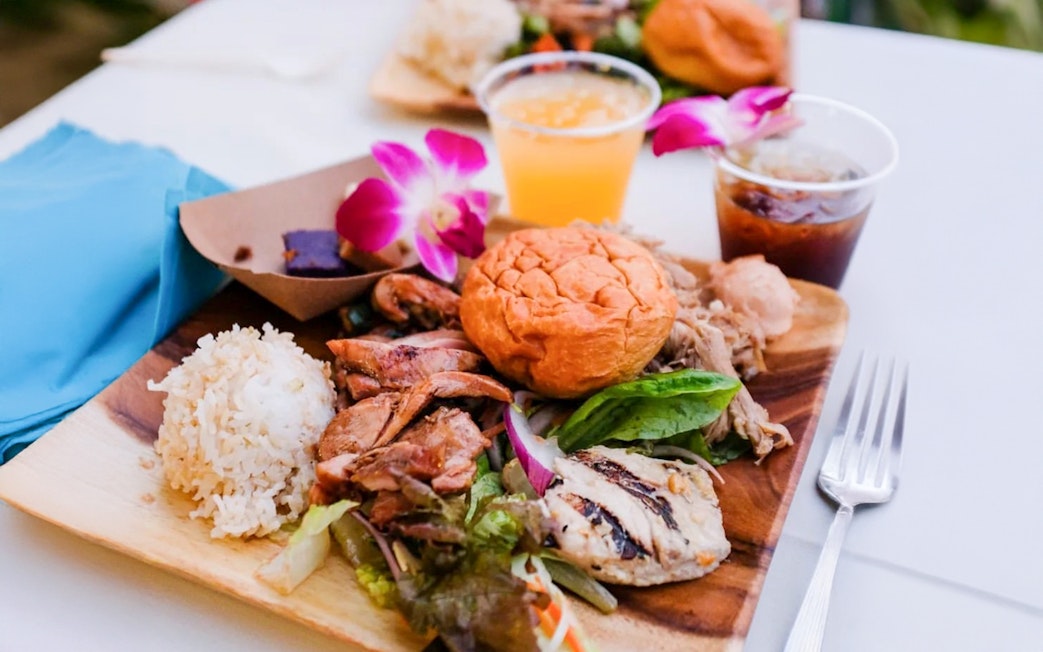 Traditional Hawaiian Luau meal with rice, grilled meats, and salad at Moana Luau, Hawaii.