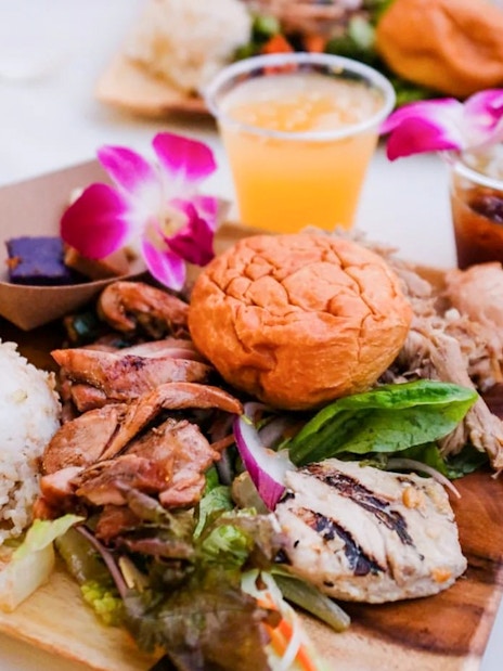 Traditional Hawaiian Luau meal with rice, grilled meats, and salad at Moana Luau, Hawaii.