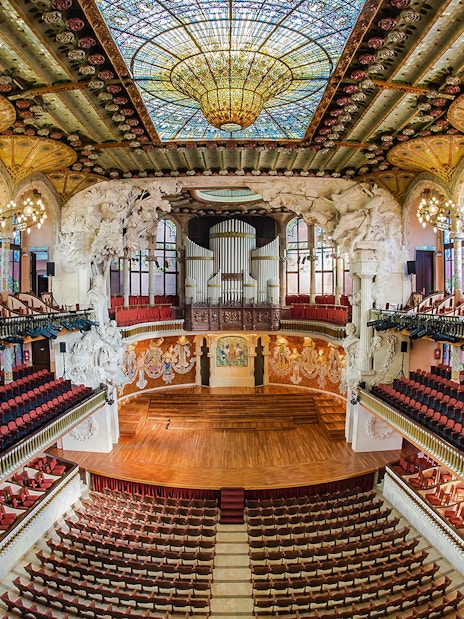 Concert Hall interior at Palau de la Musica Catalana, Barcelona, featuring stained glass and ornate architecture.