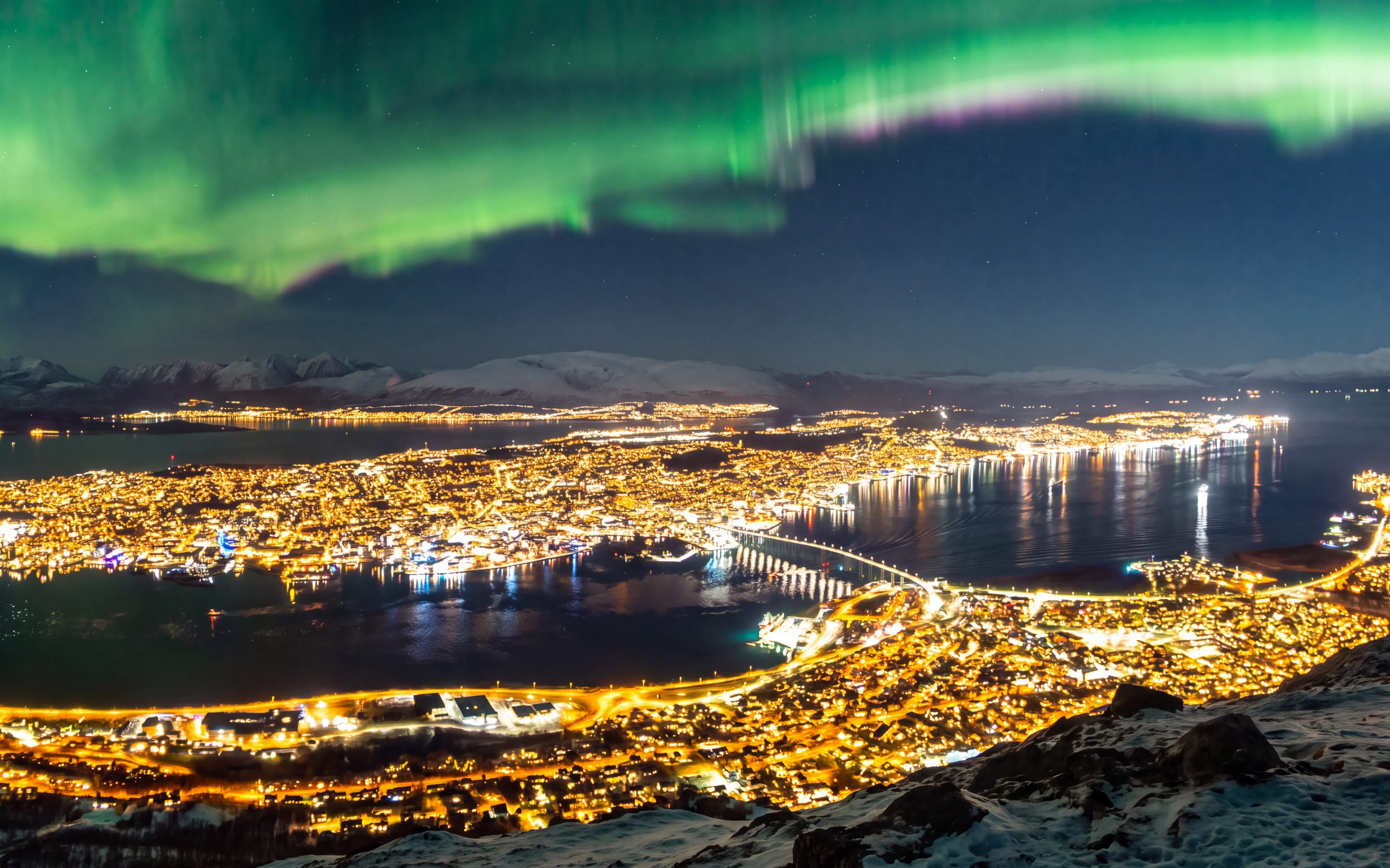 Night view of Tromsø city lights and Northern Lights from Fjellheisen.
