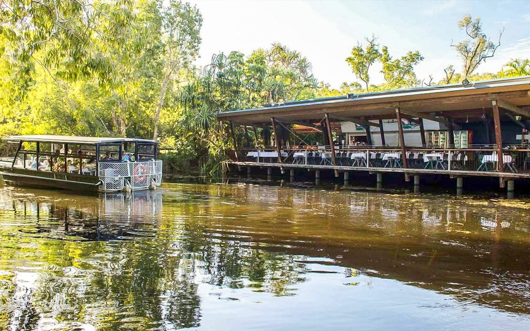 Boat tour at Hartley's Crocodile Adventures, Queensland, near a riverside restaurant.