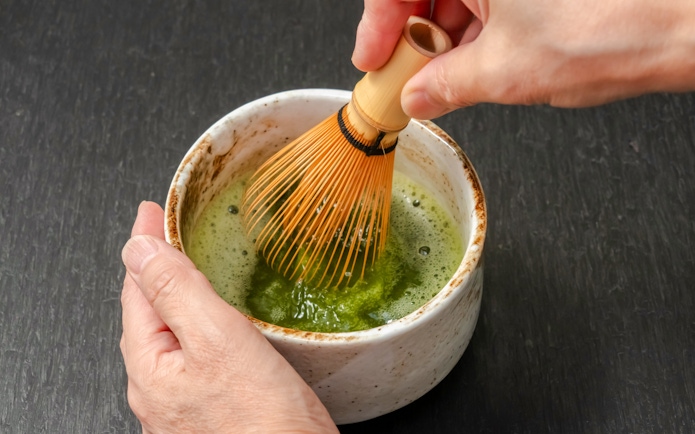 Whisking matcha in a bowl during a tea ceremony in Kyoto.