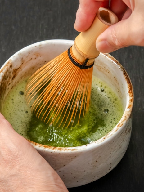 Whisking matcha in a bowl during a tea ceremony in Kyoto.