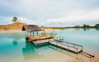 Wooden boat docked on Blue Lake near Bintan Mini Desert, Indonesia.