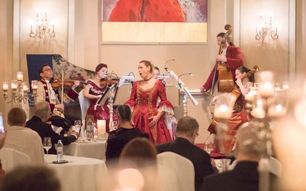 Musicians in period costumes perform at a Mozart concert in a historic Salzburg venue.