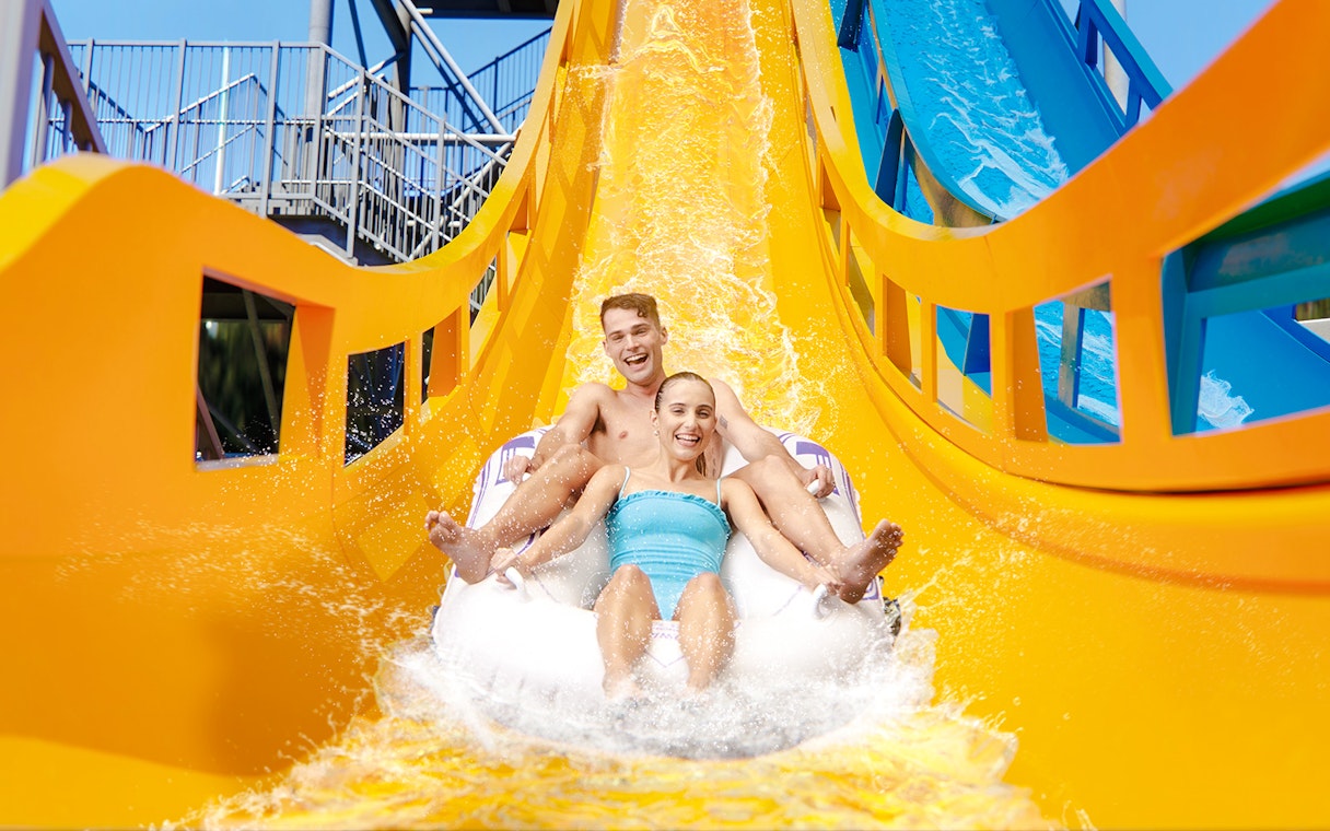 Couple enjoying Kaboom slide at Wet n Wild, Gold Coast waterslide.