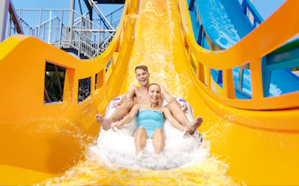 Couple enjoying Kaboom slide at Wet n Wild, Gold Coast waterslide.