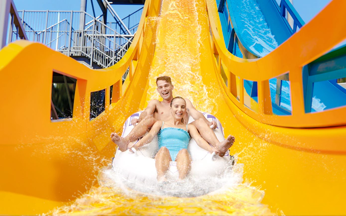 Couple enjoying Kaboom slide at Wet n Wild, Gold Coast waterslide.