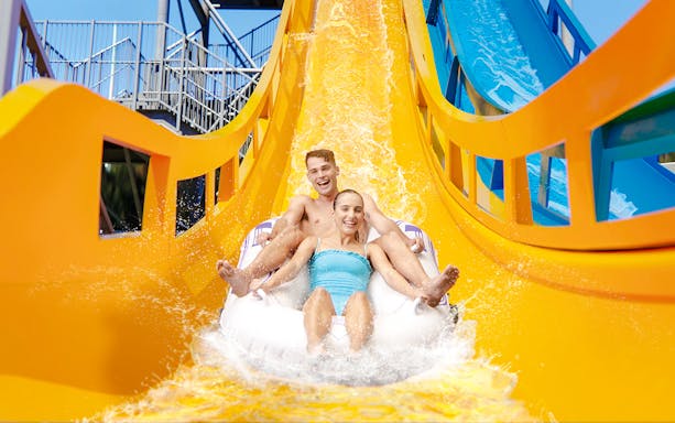 Couple enjoying Kaboom slide at Wet n Wild, Gold Coast waterslide.