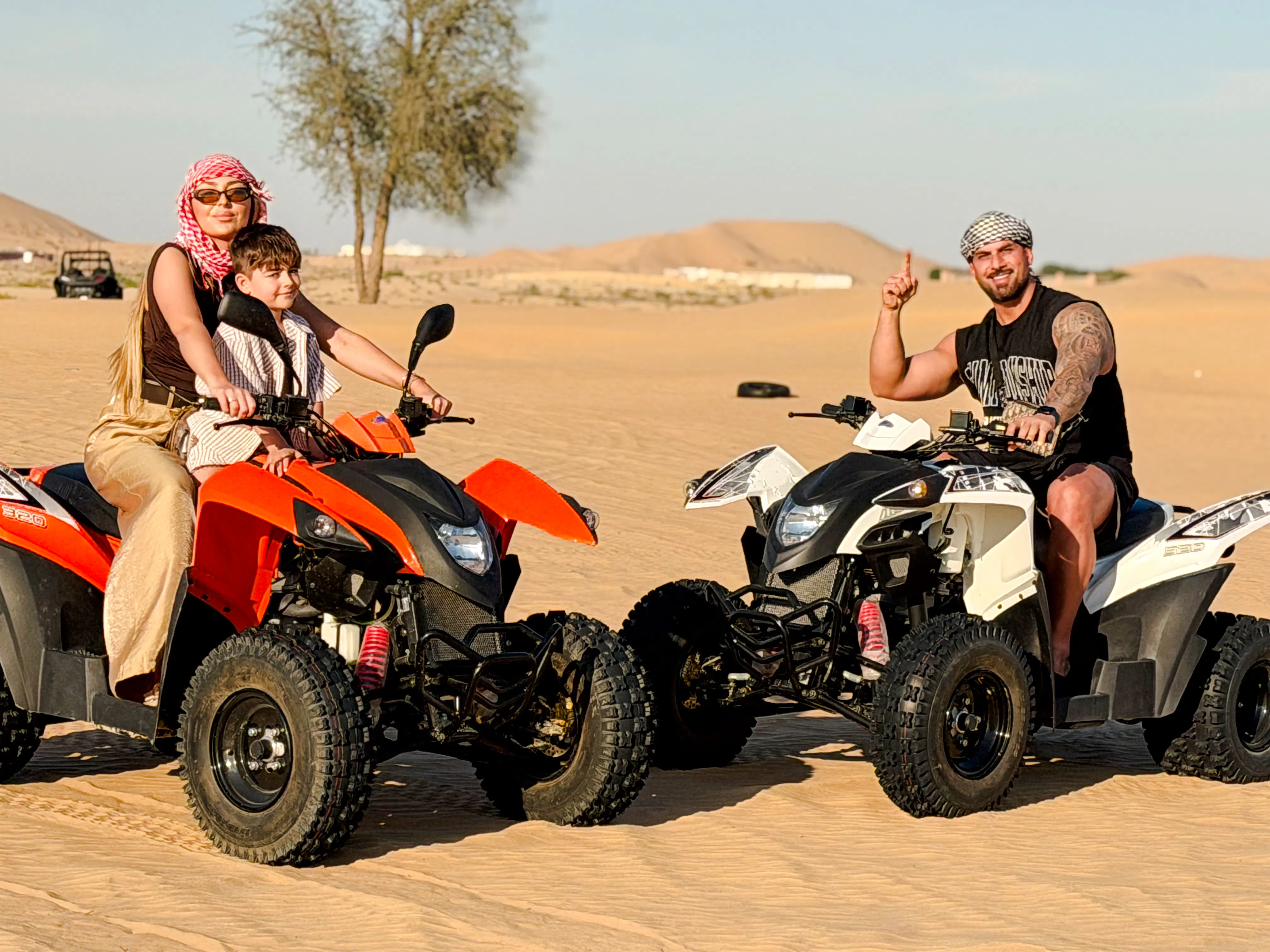 People riding quad bikes on a desert safari in Abu Dhabi.