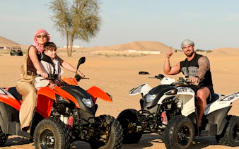 People riding quad bikes on a desert safari in Abu Dhabi.