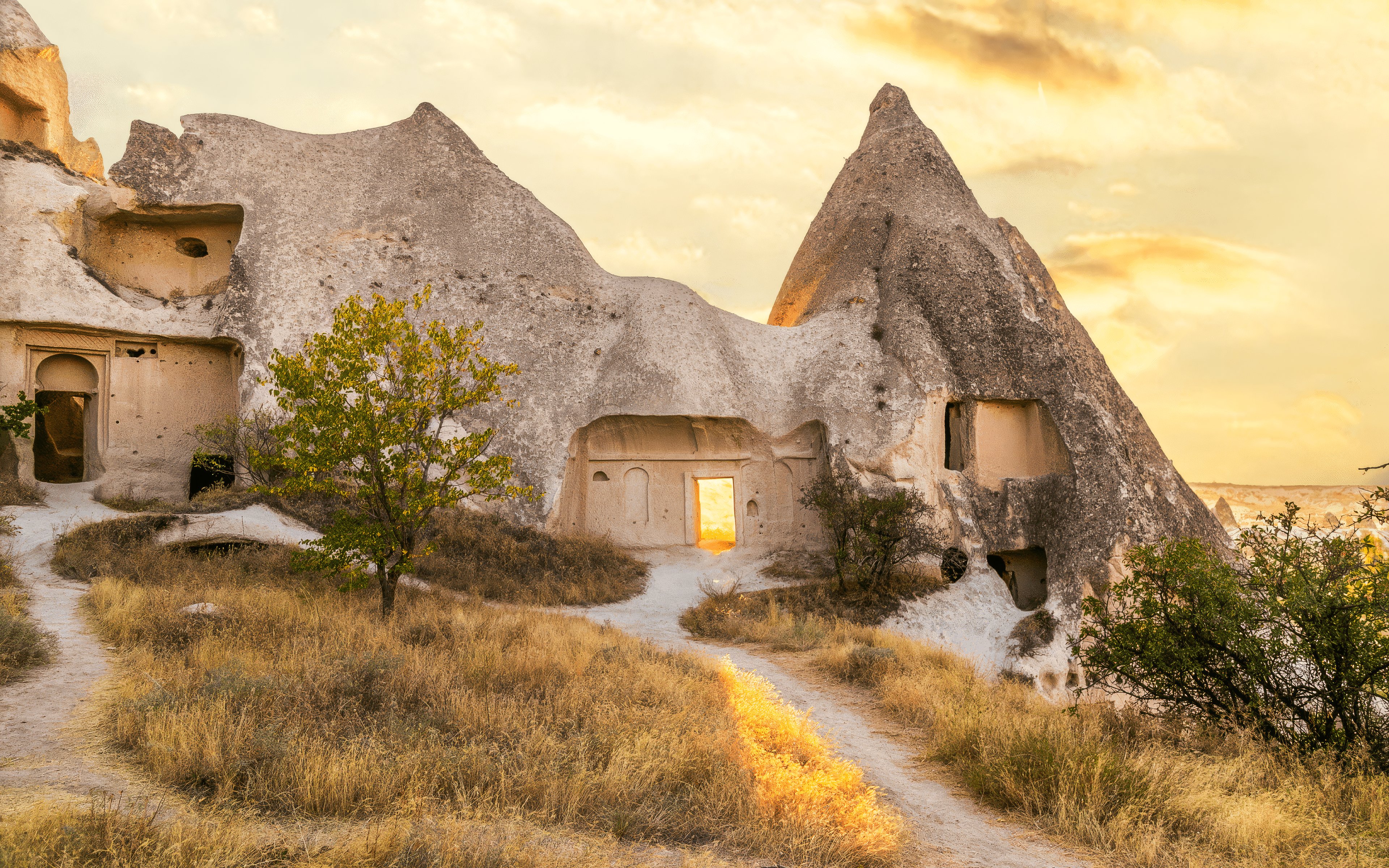 Ancient rock formations and cave dwellings in Cappadocia, Turkey at sunset.