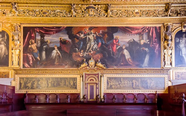 Doge Palace chamber with ornate gold detailing and historical paintings in Venice.