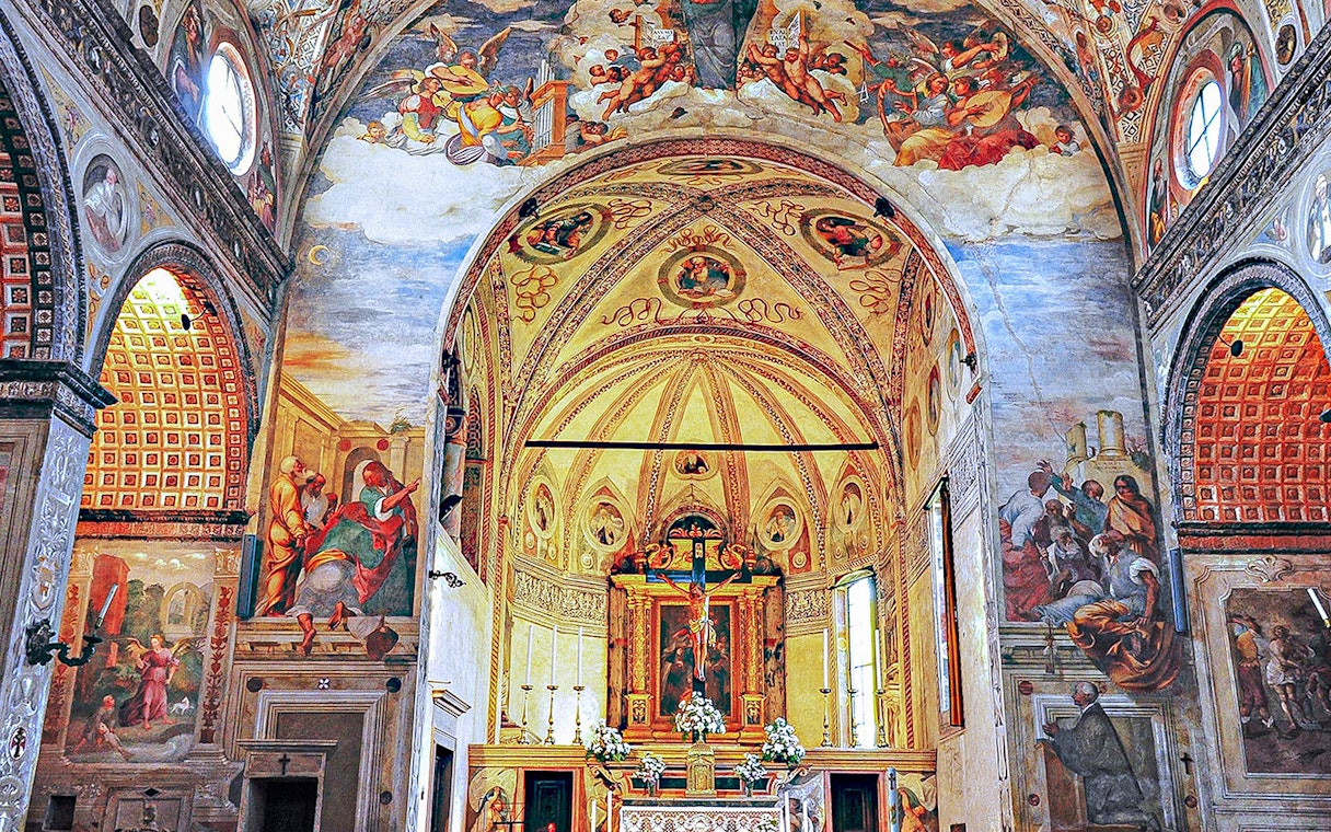 Interior of Santa Maria delle Grazie, Milan, with frescoes and ornate altar.