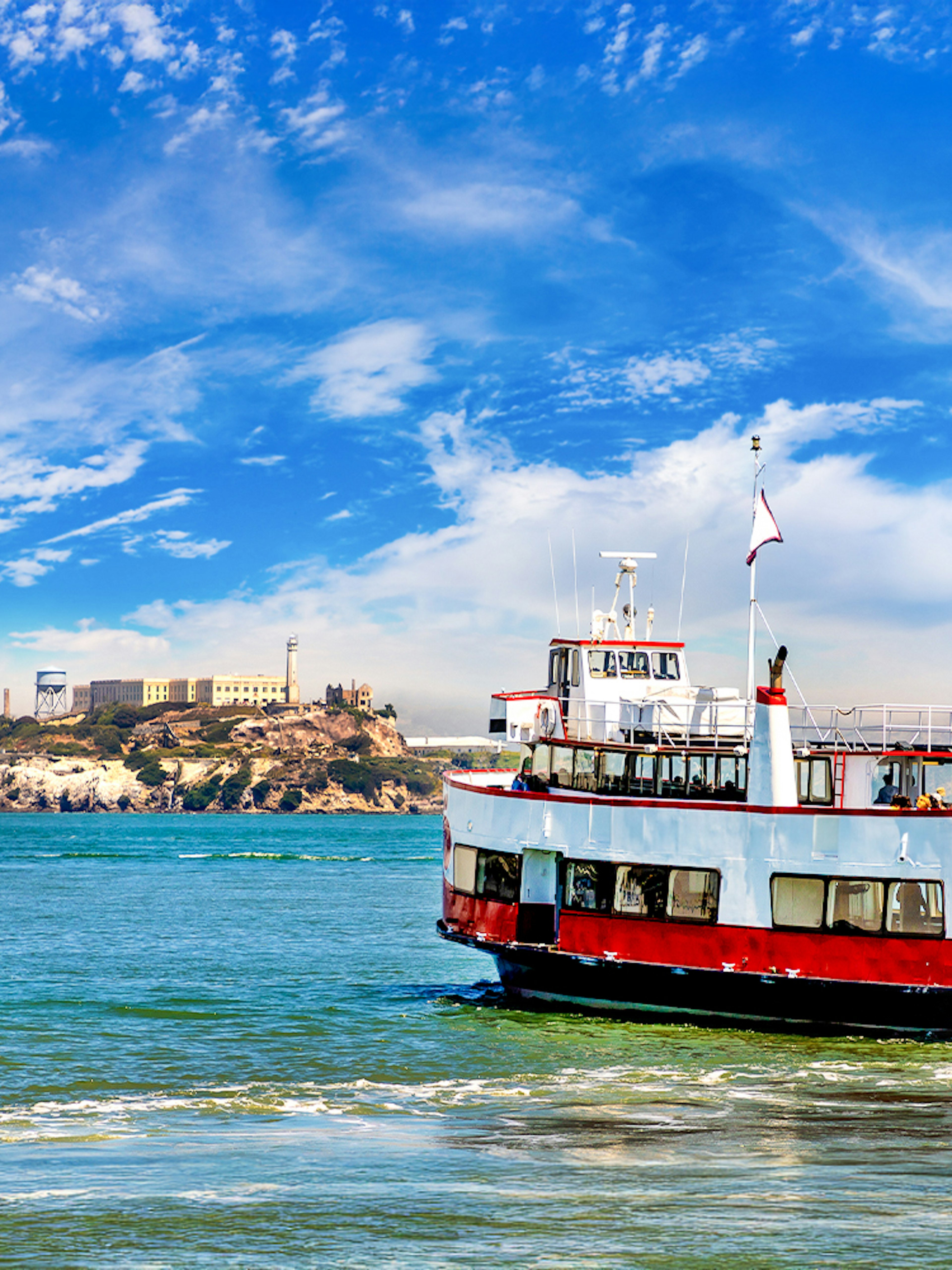 Ferry with tourists approaching Alcatraz Island in San Francisco Bay, California.