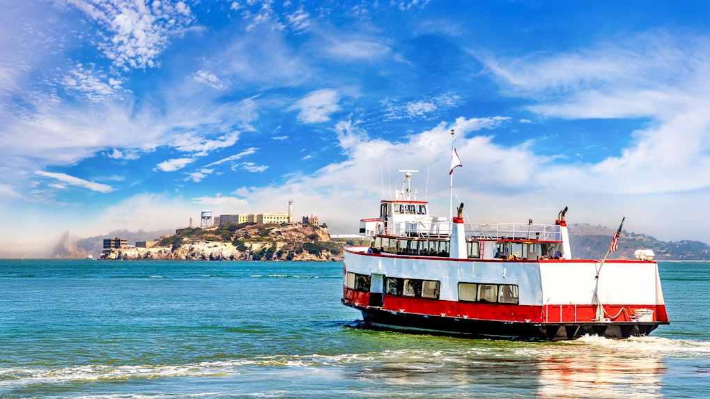 Ferry with tourists approaching Alcatraz Island in San Francisco Bay, California.