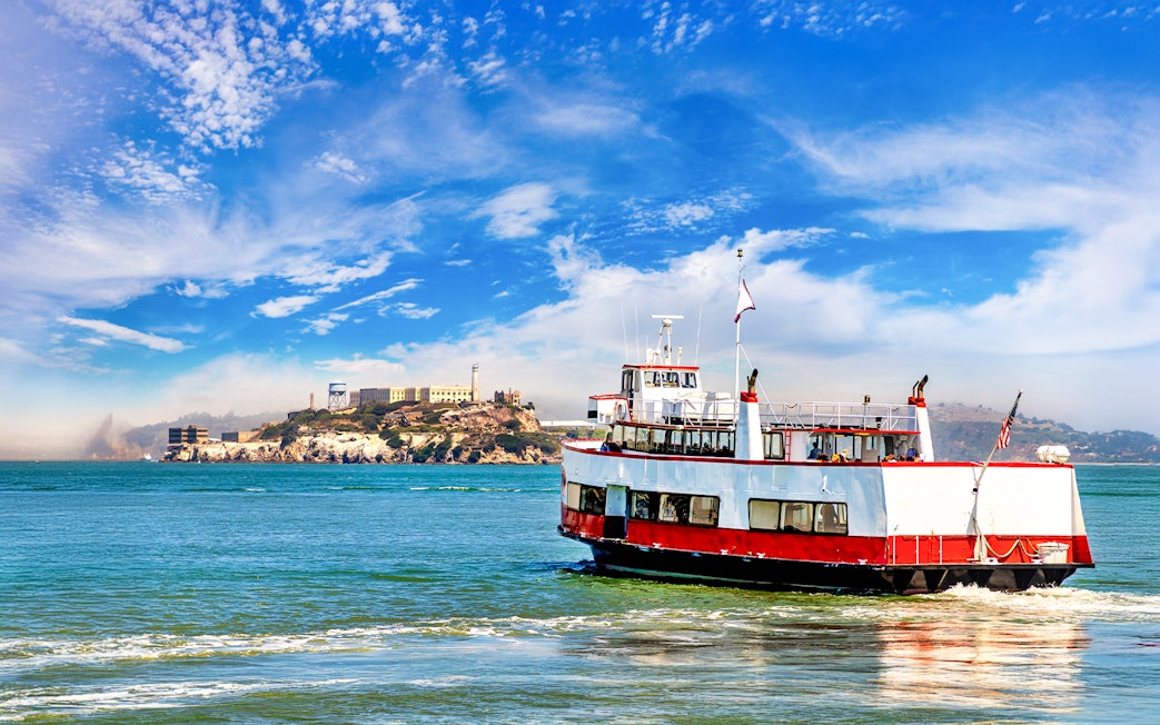 Ferry with tourists approaching Alcatraz Island in San Francisco Bay, California.