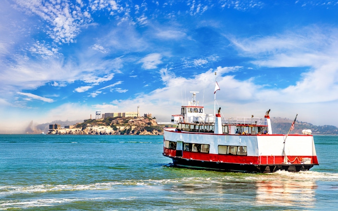 Ferry with tourists approaching Alcatraz Island in San Francisco Bay, California.