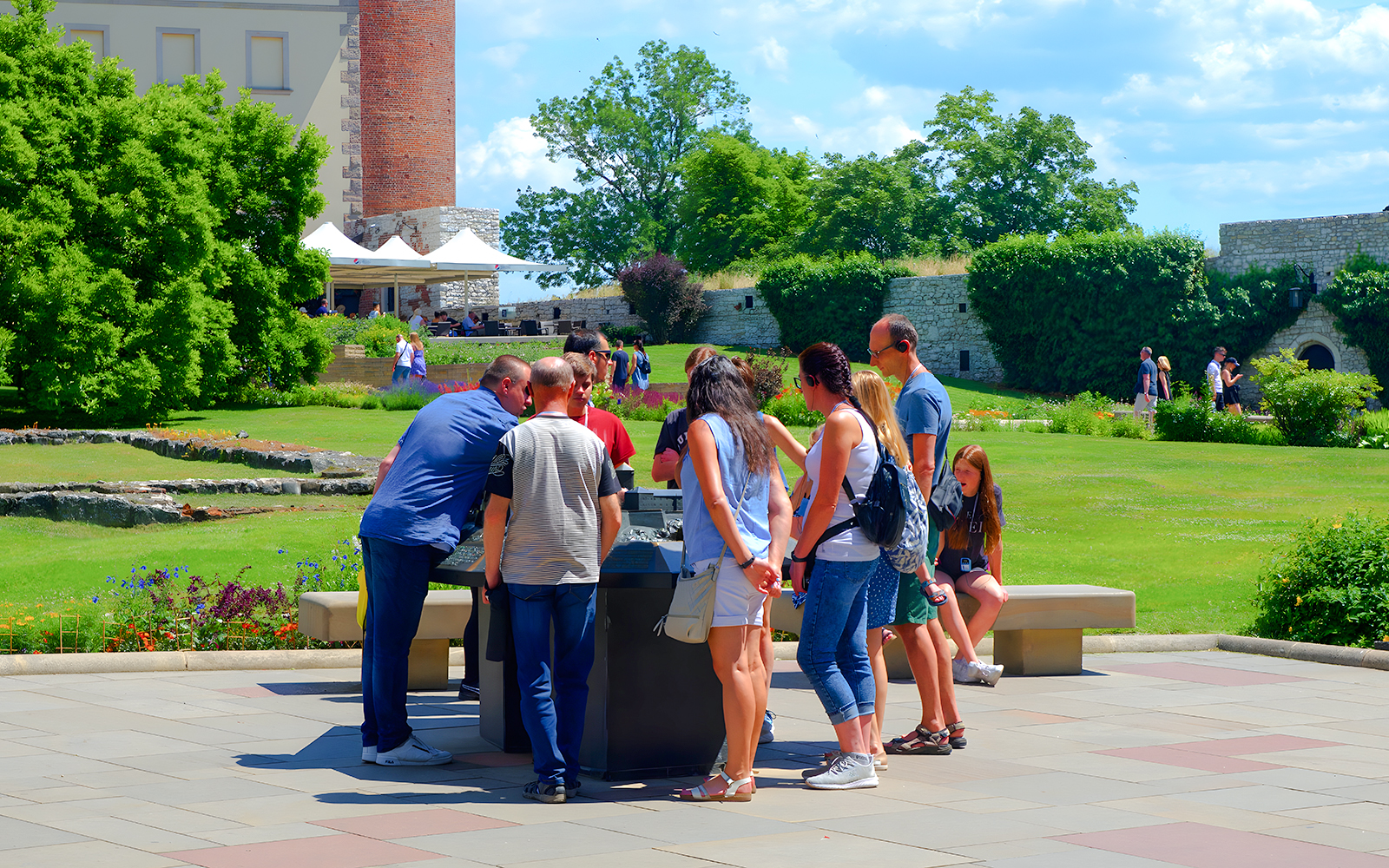 Visitors gather around a guide at Wawel Cathedral, Krakow, during a tour.