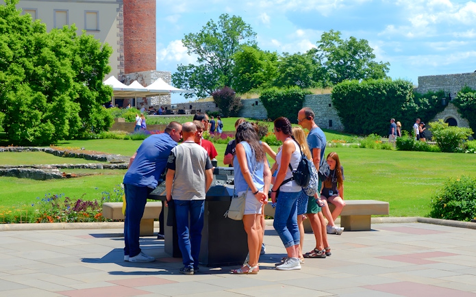 Visitors gather around a guide at Wawel Cathedral, Krakow, during a tour.