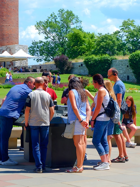 Visitors gather around a guide at Wawel Cathedral, Krakow, during a tour.