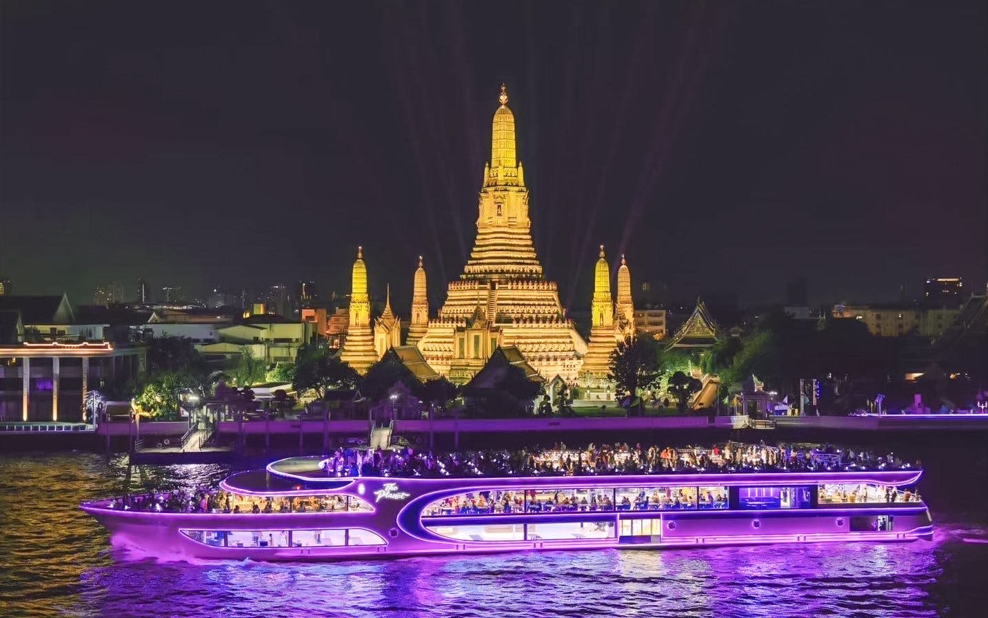 Dinner cruise at Asiatique Pier with Wat Arun illuminated in the background, Bangkok.