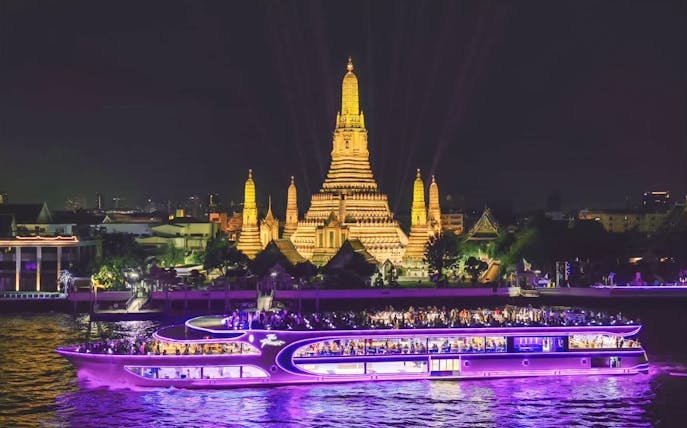 Dinner cruise at Asiatique Pier with Wat Arun illuminated in the background, Bangkok.
